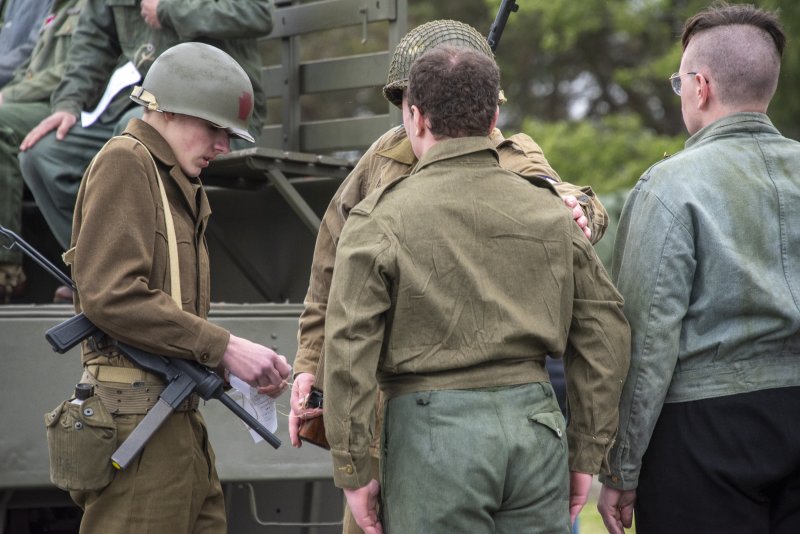 A German submarine soldier is arrested and tagged before being loaded on the truck for transport.